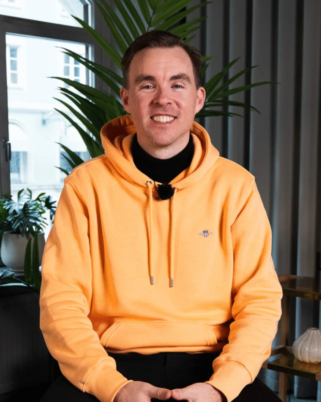 Sibbe Silvén i enfärgad hoodie med keps, naturligt ljus